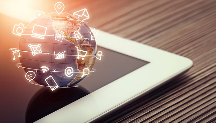 Media app icons flying around globe on tablet computer